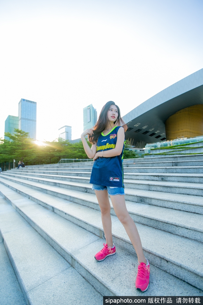 一位篮球宝贝双手指向镜头,神情俏皮又充满自信,身后的队友身影虚化,突显出她个人独特的青春魅力。