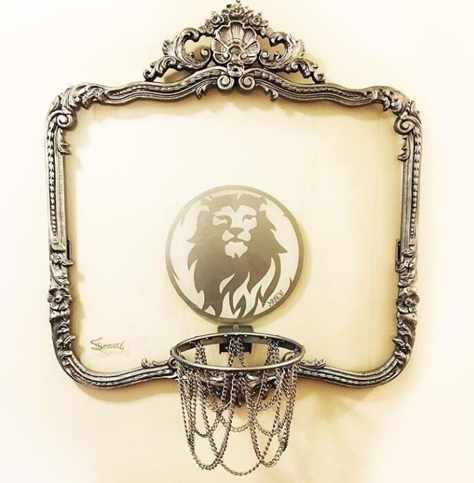 从篮板侧面看去,透明的材质让篮筐仿佛悬浮在空中,背景是模糊的绿树与天空,构成一幅动静结合的运动画卷。