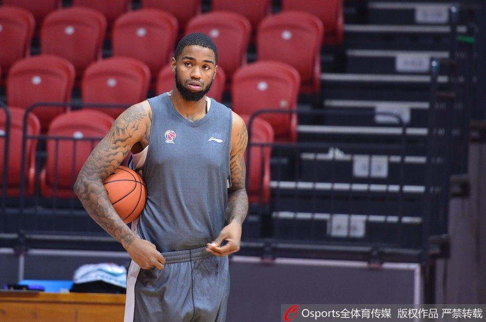 肖恩朗在新疆队训练馆里双手大力灌篮，肌肉线条分明，落地后眼神坚毅盯着篮筐，仿佛要把憋着的劲全使出来