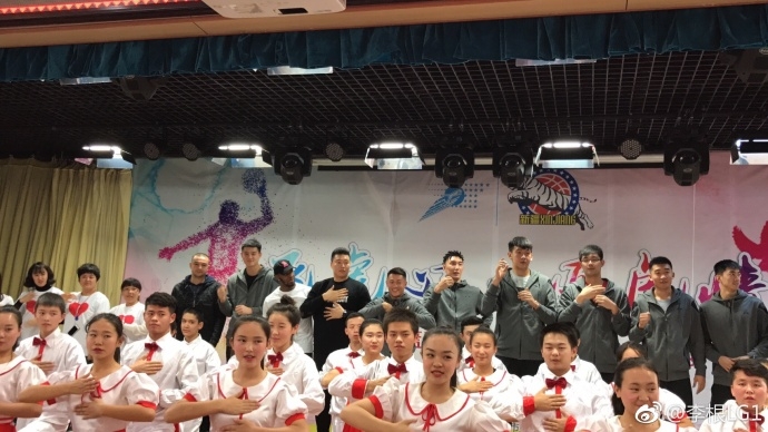 可兰白克蹲在孩子们中间,与大家一起做互动游戏,他的脸上满是温暖的笑意,孩子们也沉浸在欢乐的氛围中,画面温馨和谐