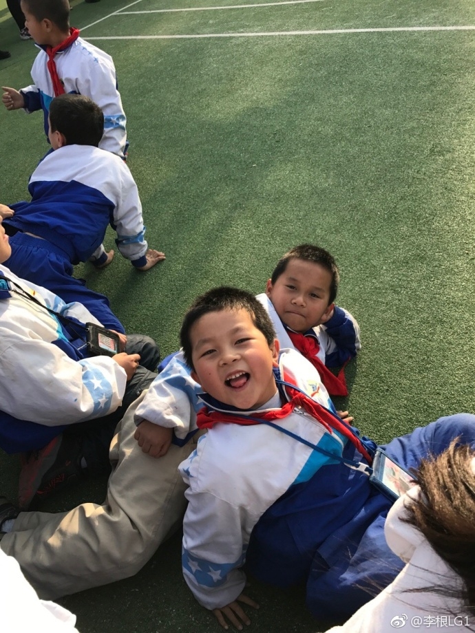 新疆男篮的球员们微笑着步入校园,他们手中提着精心准备的篮球和礼物,孩子们眼中闪烁着期待与兴奋的光芒