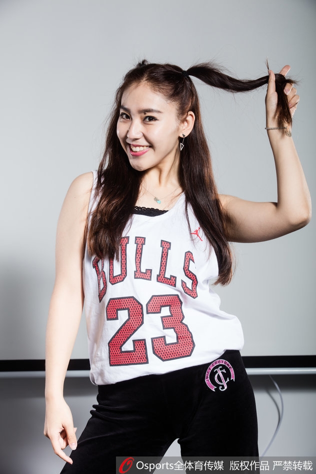 扎着俏皮双马尾的啦啦队员，回眸一笑，灵动的眼神在球馆灯光下闪烁着星辰般的光芒，青春的活力扑面而来。