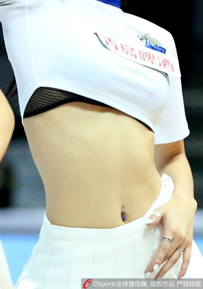 一位篮球宝贝在表演间隙整理秀发,随性的动作中透露出优雅,背后是模糊的看台人潮,这一刻仿佛喧嚣中的宁静,充满了故事感。