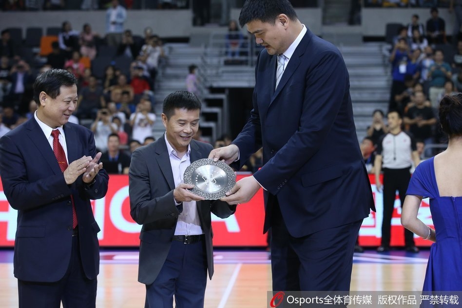 陈海涛（中）代父领奖时，脸上洋溢着自豪与感动，身后的大屏幕上播放着宏远名宿们的祝福，这一刻家族的荣耀与篮球的传承交织在一起。