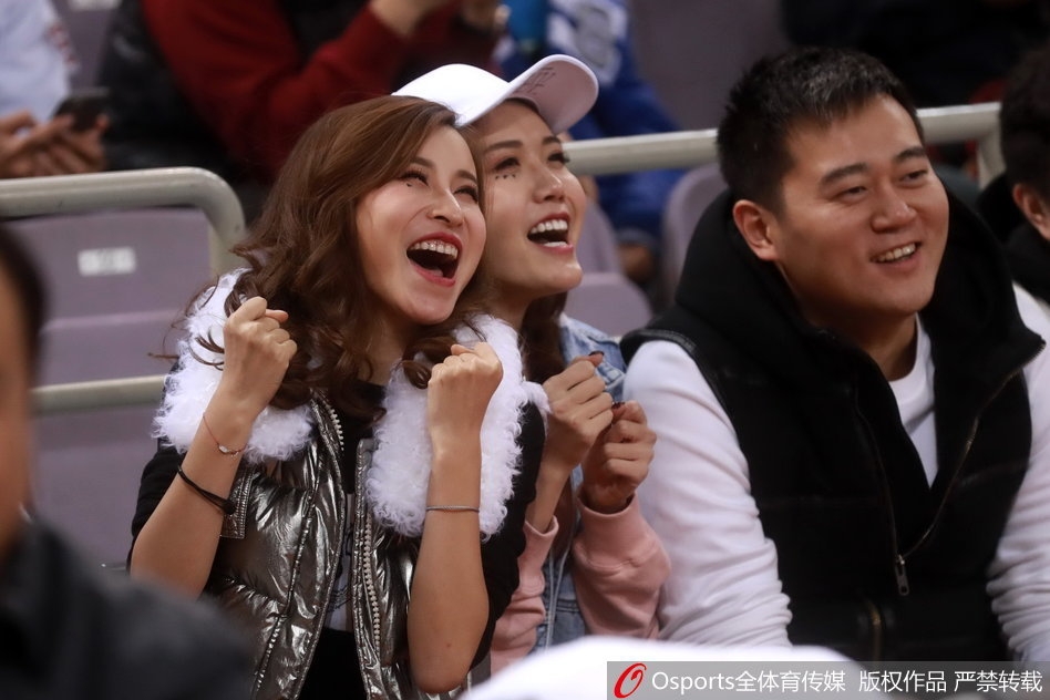 扎着丸子头的俏皮女球迷，表情略带嗔怪，嘟着嘴看向赛场，流露出对球队表现既失望又难舍的复杂情感。