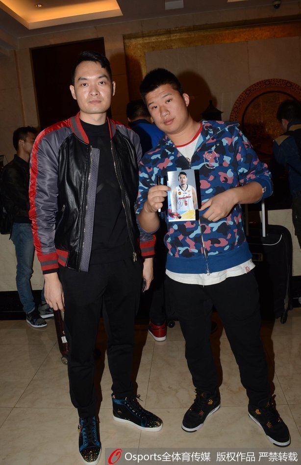 镜头拉近，易建联目光专注，手中的笔在球迷递来的纪念品上留下珍贵的签名，没有丝毫明星架子。