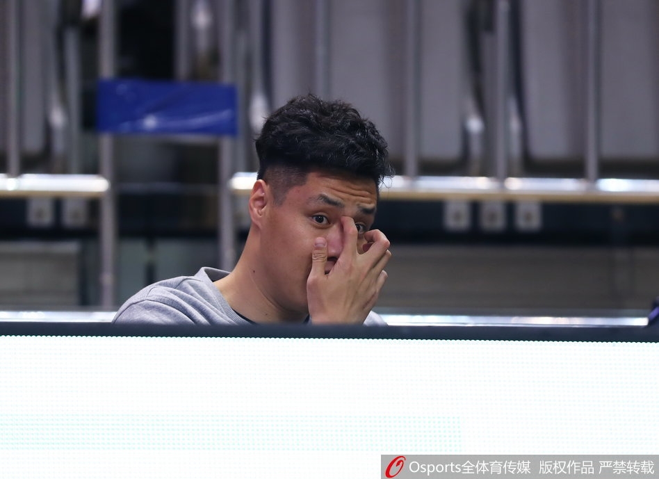 贺天举手搭毛巾表情轻松,在替补席上与队友谈笑风生