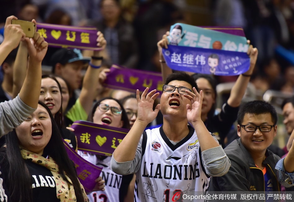 镜头特写一位满脸涂着蓝色油彩的辽宁老球迷，他眼含热泪挥舞着手中的围巾，身后是模糊的记分牌，显示辽宁队大比分领先，那份自豪感呼之欲出。