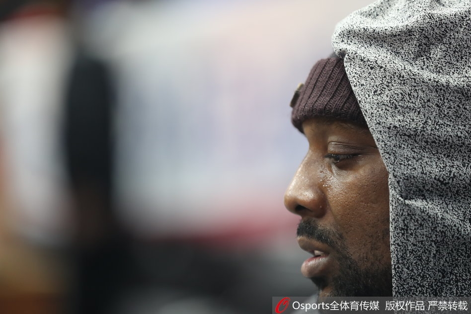 布拉切从座位上起身，宽松的衬衫下摆露出，略显笨拙的身形透露出一丝无奈与慵懒。