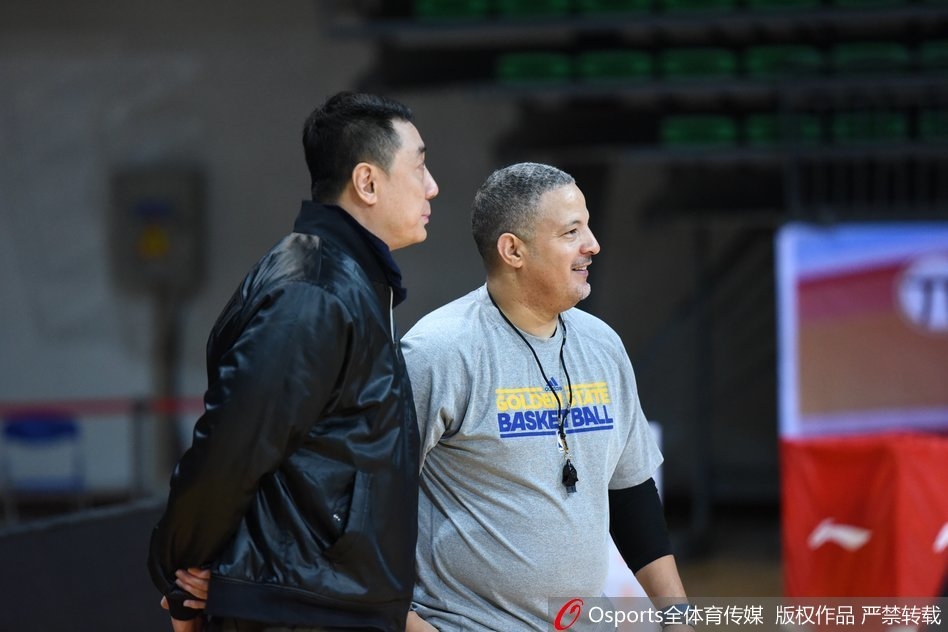 王非与休利并肩而立，目光如炬地注视着场上的训练，两位老友的默契在无声中传递。