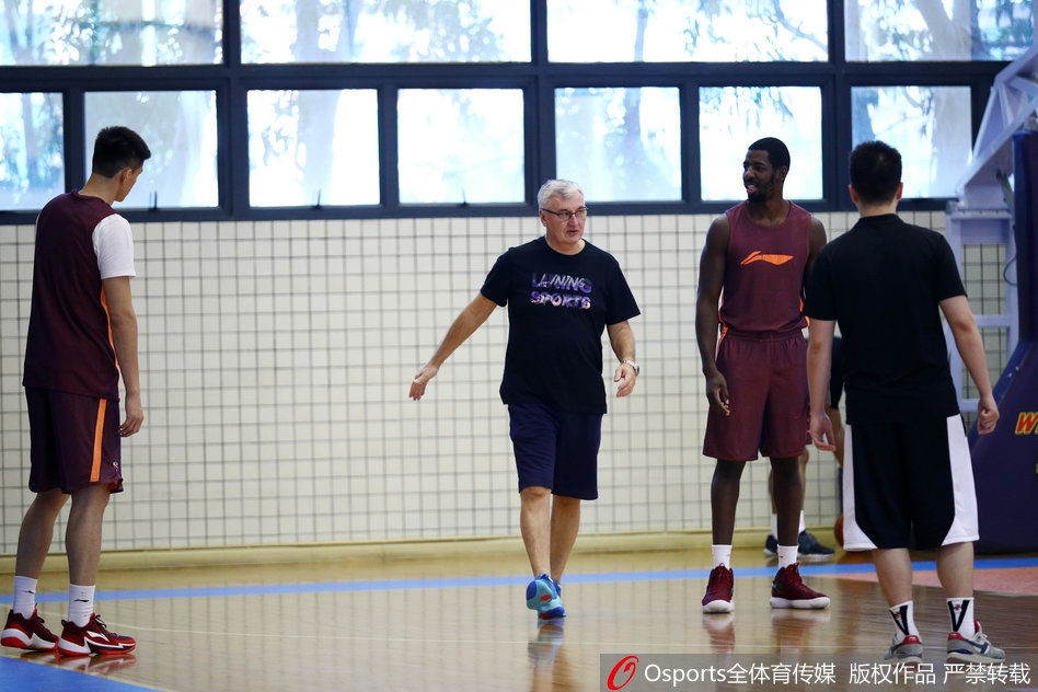 广东宏远全队在进行放松拉伸,夕阳透过窗户洒在球员们身上,映照出一张张坚毅而充满信心的脸庞。