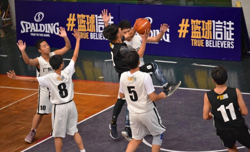 云山学校两名队员在禁区筑起铜墙铁壁,他们高高跃起,伸展长臂,用坚决的封盖试图阻挡对手的强力上篮,眼神中透出绝不退让的坚毅。