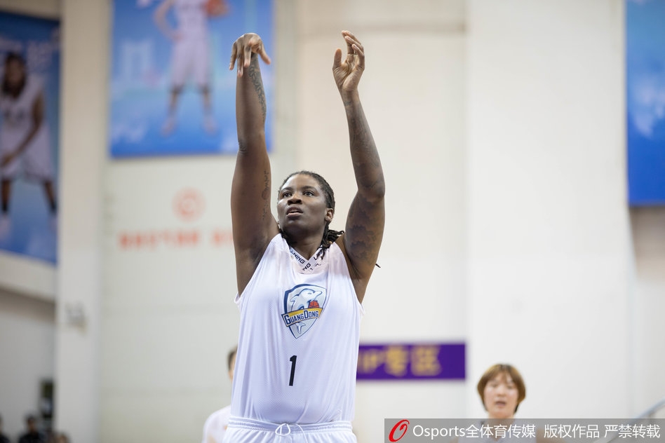 广东女篮主教练在场边激情指挥，他张大了嘴巴，双手比划着战术手势，神情专注而严肃，试图通过呐喊稳住场上的局面。