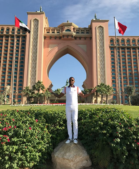 亚当斯身穿简约的白色T恤,在迪拜的建筑背景下单手插兜,表情自信而放松,宛如时尚大片。