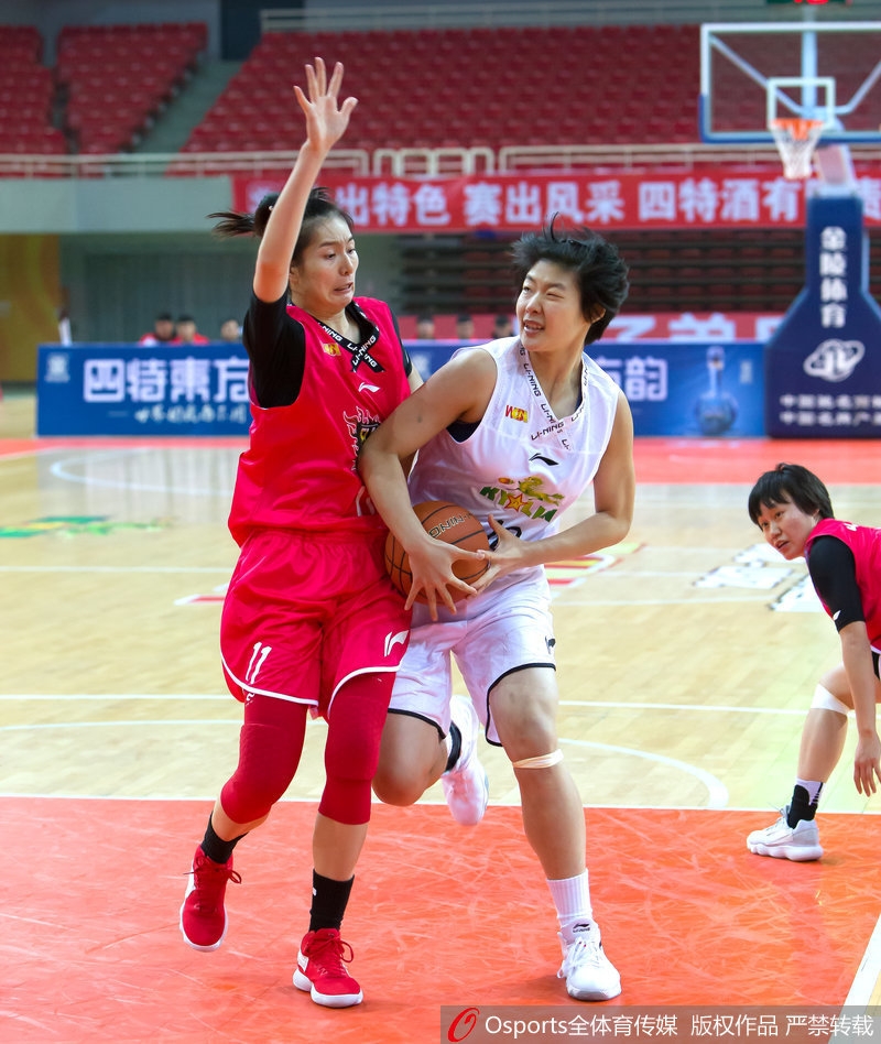 八一女篮球员在对手篮下高高跃起，以一记精彩的补篮点燃全场观众的热情