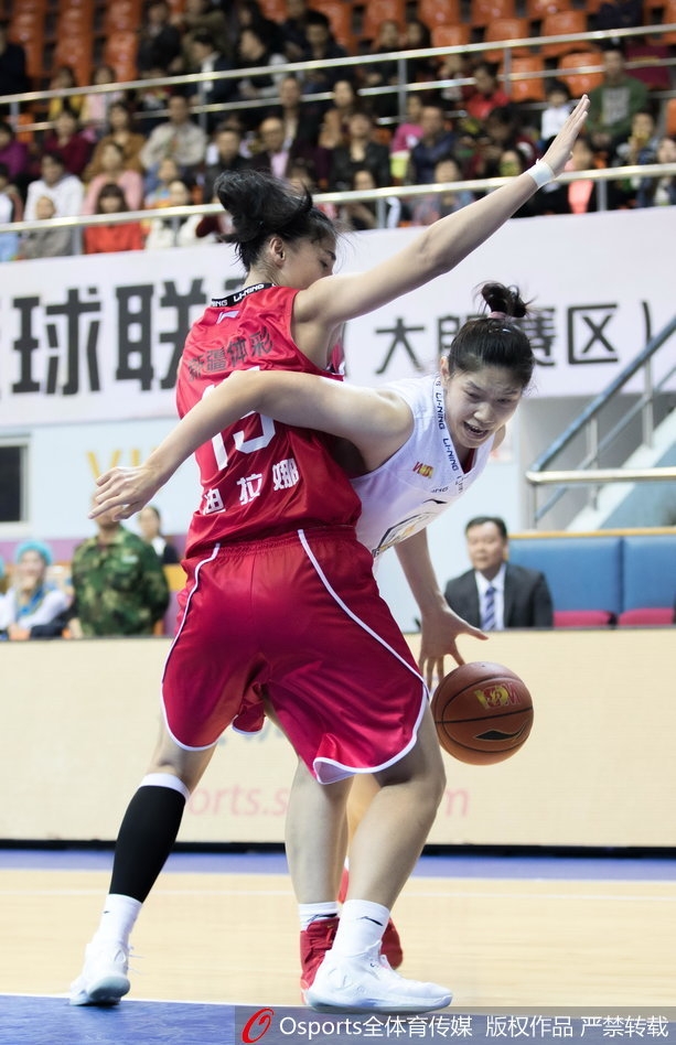 新疆球员迪拉娜在对抗中高高跃起，与广东队防守球员激烈拼抢篮板球。两人在空中形成错位，肌肉碰撞的声音仿佛穿透了画面。