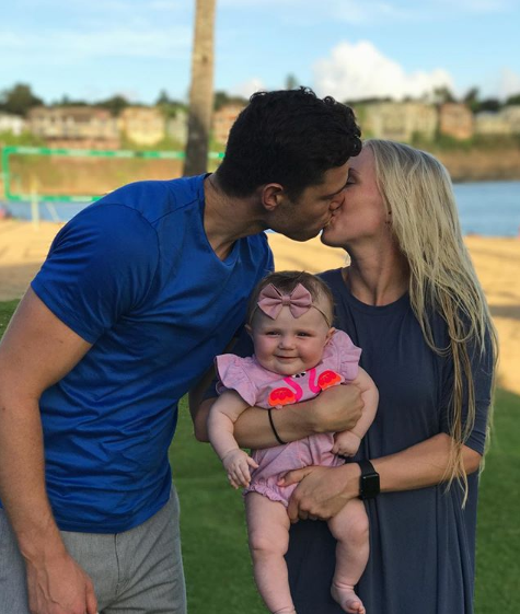 弗雷戴特抱着女儿，小家伙好奇地望向镜头，爸爸则满脸骄傲与幸福，背景透着居家的温馨气息