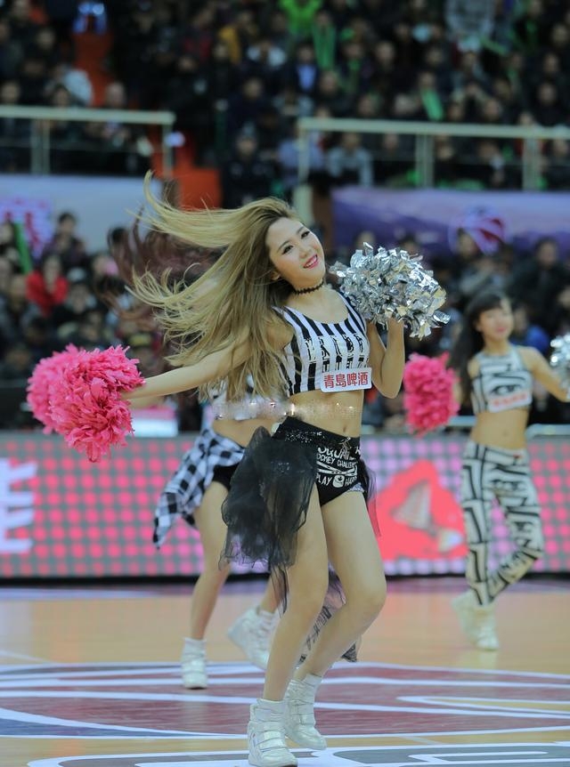 在温暖的室内，一位篮球宝贝身着她标志性的黄色表演服，回眸看向镜头，眼神中带着一丝笑意与灵动，仿佛在与摄影师进行一场无声的对话。