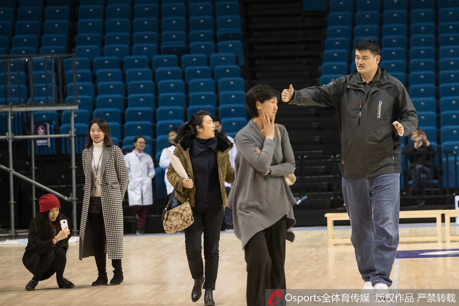 姚明双手抱胸伫立赛场边，目光如炬注视着场上飞奔的弟子们，神情中流露出对年轻一代的深切期望。