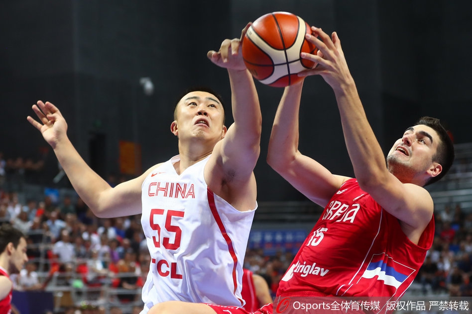 任骏飞持球强势突破塞尔维亚两人防线，眼神坚毅，身体对抗中展现出核心球员的霸气与决心