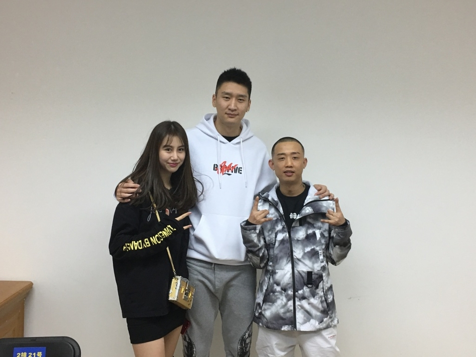 孙悦面带微笑与妻子陈露、GAI并肩站立，三人眼神默契，陈露的甜美笑容和GAI的标志性手势构成一幅和谐的跨界友谊画面。