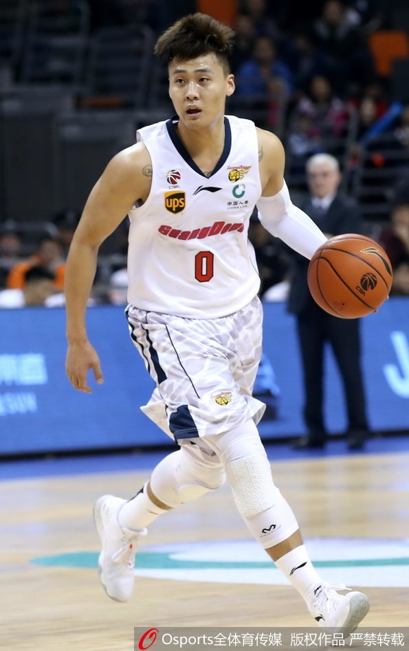 青岛队外援吉布森在易建联的长臂干扰下强行突破上篮,尽管身体失去平衡,他依然奋力将球抛出,眼神中透露出不甘与顽强。