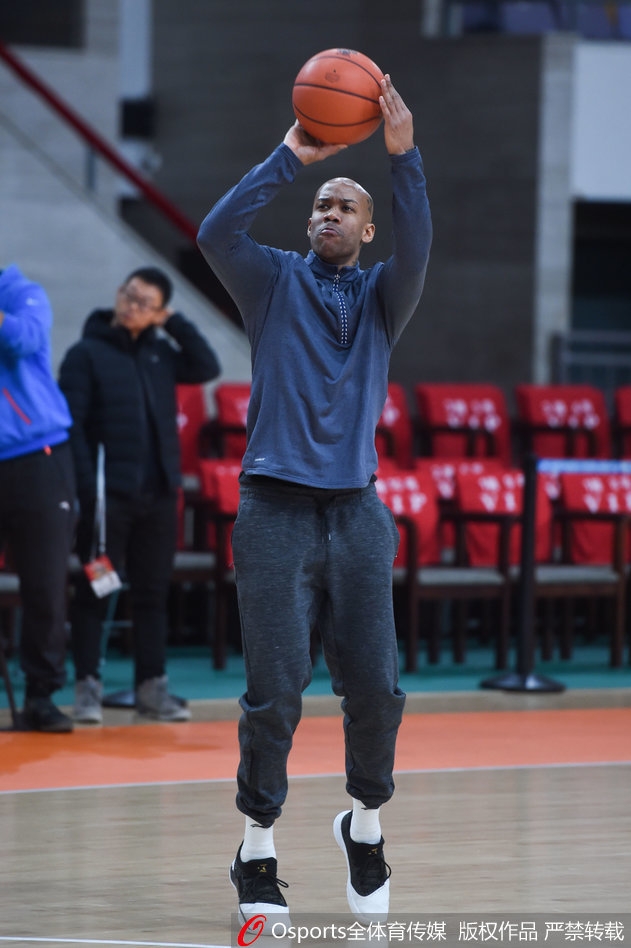 阿巴斯正在进行单独的韧带拉伸，身体柔韧性展现无遗，身后的马布里恰好虚化成了背景，象征着两人在场上既独立又相互支撑的角色。