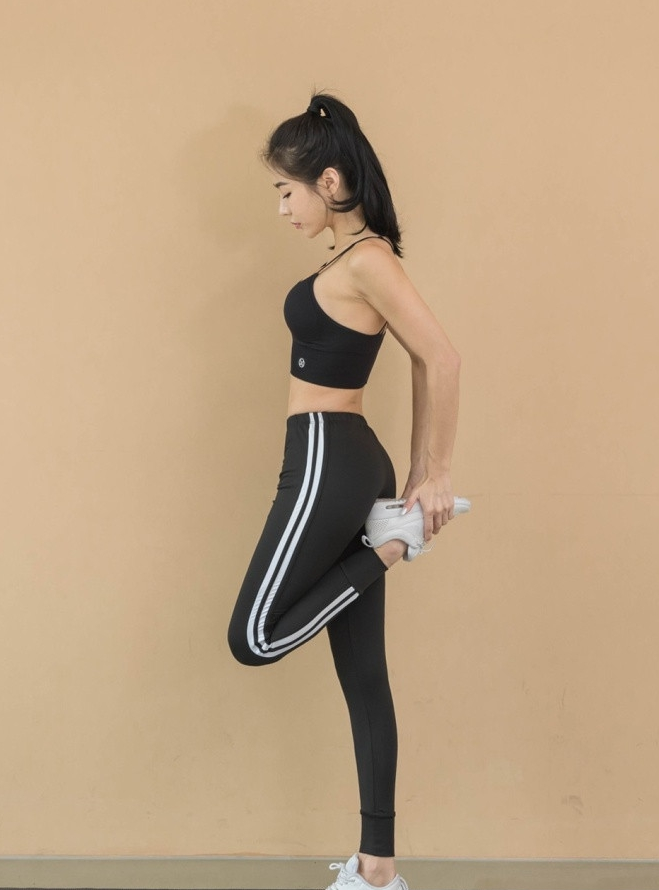 疾速奔跑中的黑衣少女，发丝随风飞扬，黑色的运动服紧紧贴合着她流畅的身体曲线，仿佛一只在丛林中穿梭的黑豹，充满了原始的野性与速度感。