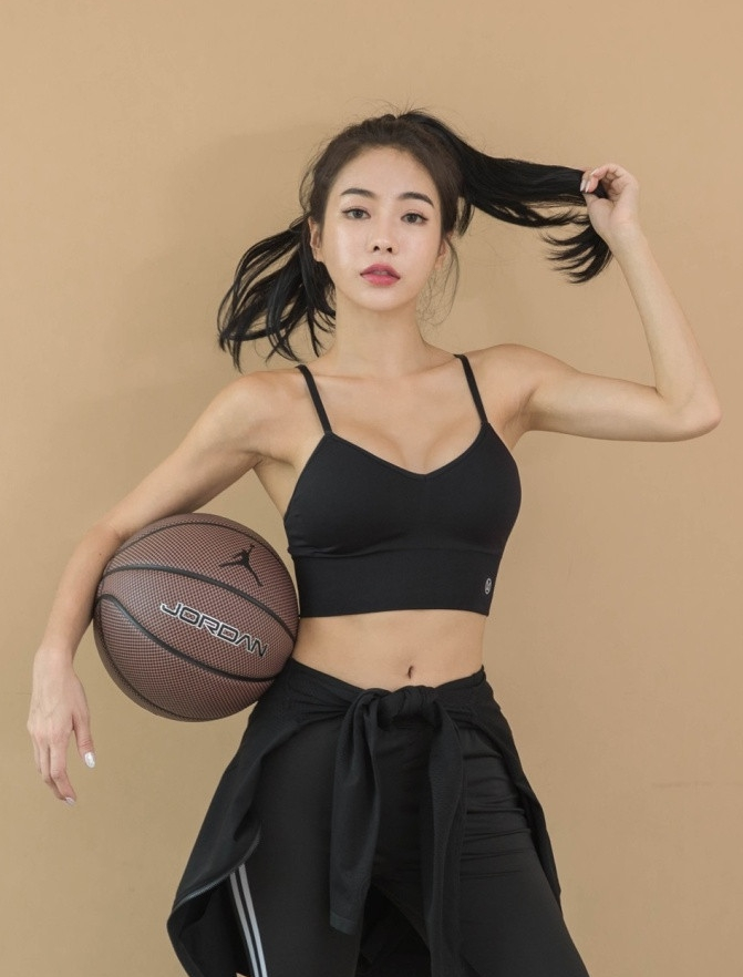 镜头定格在一位身穿黑色运动衣的姑娘身上，她正全神贯注地做着赛前准备，舒展的肌肉线条在阳光下闪烁着健康的光泽，每一帧都是力与美的完美结合。