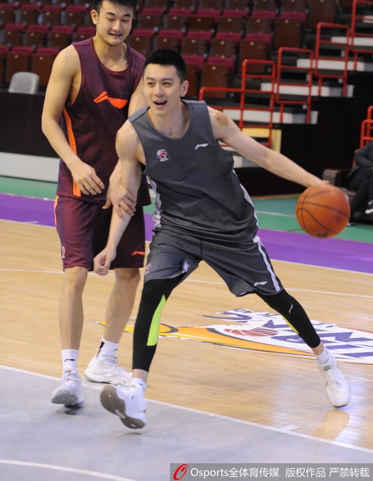 杰特身穿训练服，在与巴斯交流时神情专注，嘴角带着微笑，仿佛在分享什么球场趣事。