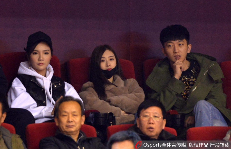 丁彦雨航的女友与睢冉的妻子在喧闹的看台上窃窃私语,脸上带着默契的微笑,仿佛在分享着只有彼此才懂的秘密。