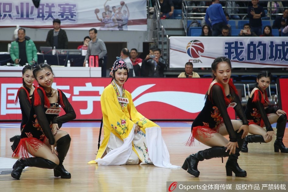 几位篮球宝贝身着华丽戏曲服饰，头戴精美头面，在球场中央摆出戏曲亮相身段，身后的观众席座无虚席，传统与时尚在此刻交汇。