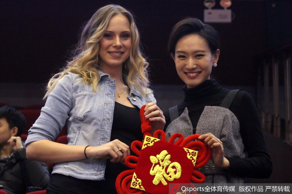 在球场璀璨灯光的映照下,她微微侧首,手中的福字宛如一抹东方胭脂,点缀在她白皙的面庞旁,那不经意间流露的嫣然一笑,足以融化北方冬夜的寒冰。