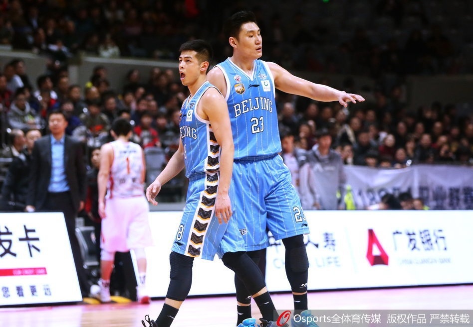 北京队外援面对防守球员的长臂干扰，依然跳起传球，皮球划出一道弧线飞向底角的空位队友，指挥若定的神情彰显核心本色。
