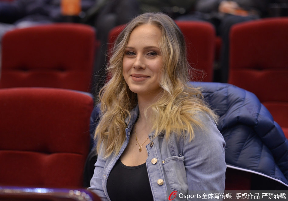 当丈夫在场上奋力拼杀时,她安静地坐在家属区,双手轻握福字置于膝上,目光越过人群深情地望向场内,嘴角那一抹弧度里,藏着只有枕边人才懂的鼓励与柔情。