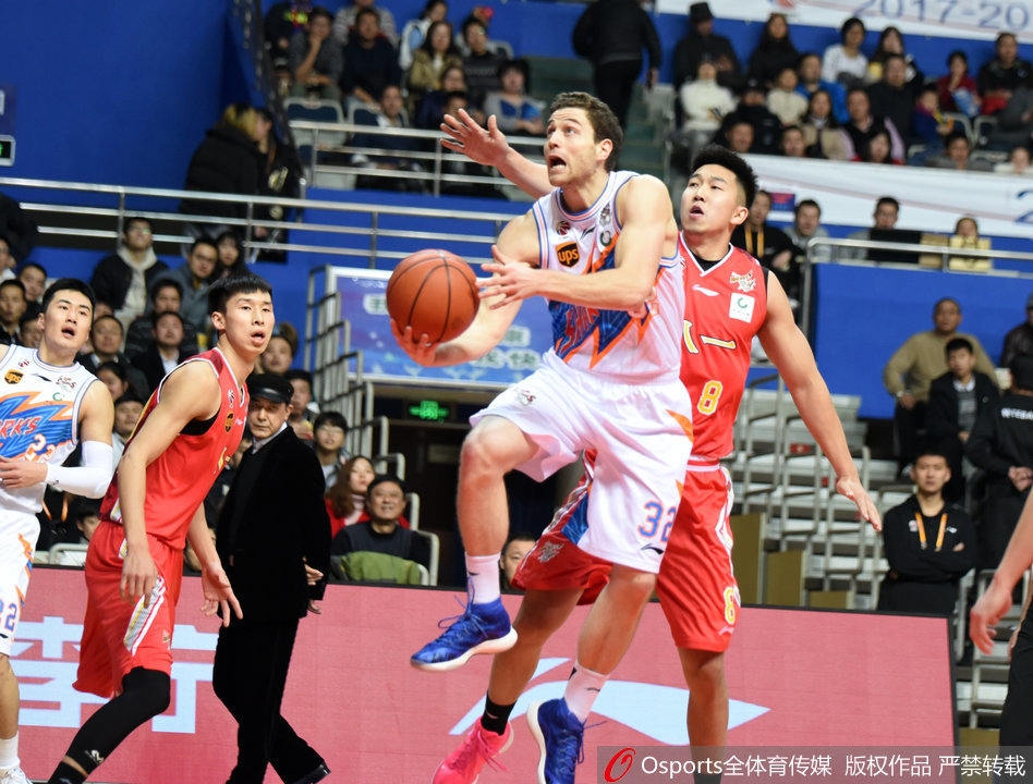 八一队内线悍将付豪在三人合围之下强行起跳上篮，他肌肉紧绷，眼神坚毅，在空中与上海队的防守球员形成激烈的对抗。