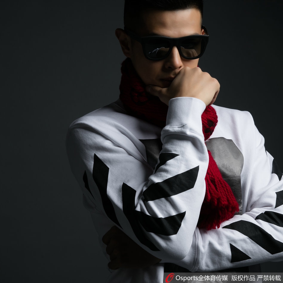 方硕正面坐姿照，身穿质感细腻的黑色毛衣，面带微笑，阳光洒在脸上，亲和力十足。