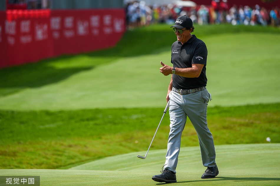 菲尔-米克尔森挥杆瞬间，身体优雅扭转，球杆划出一道完美弧线，目光专注地望向远方落点。