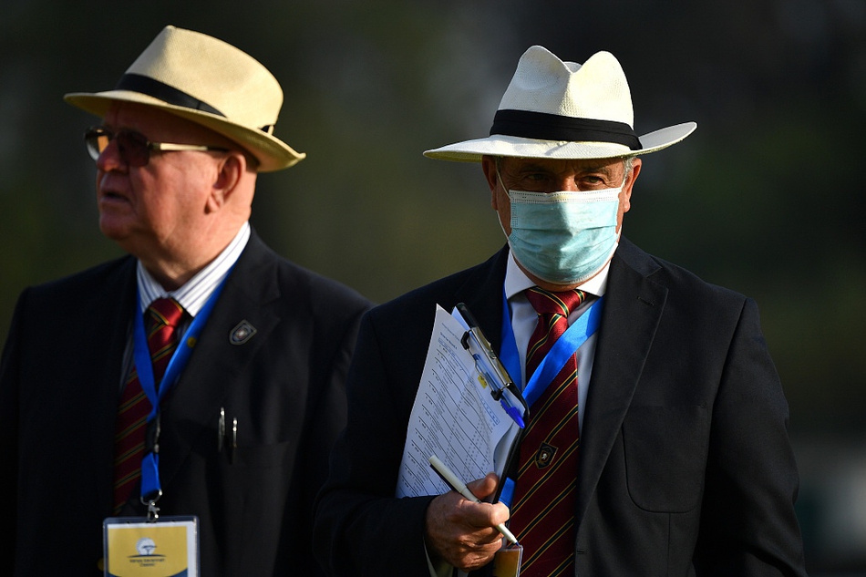 范通德与妻子在球场边含笑低语，共享比赛间隙的宁静时刻