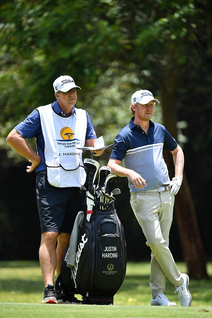 杰尼瓦塔纳隆在果岭上细致研判推杆线路，周围观众静默期待