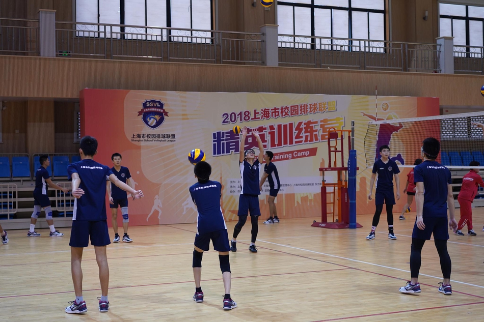 冬日球馆内，身着统一红色训练服的上海校园排球少年们目光坚毅，在一次次的起跳与扣杀中挥洒汗水，他们挺拔的身影在灯光下映出青春的轮廓，仿佛一颗颗正待打磨的排球新星。