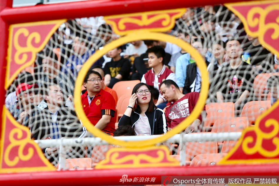 春日的淄博体育中心，一位面容清秀的女球迷在看台上静静凝望，身后是喧嚣的助威人群，她眼中的期待却比阳光更耀眼。