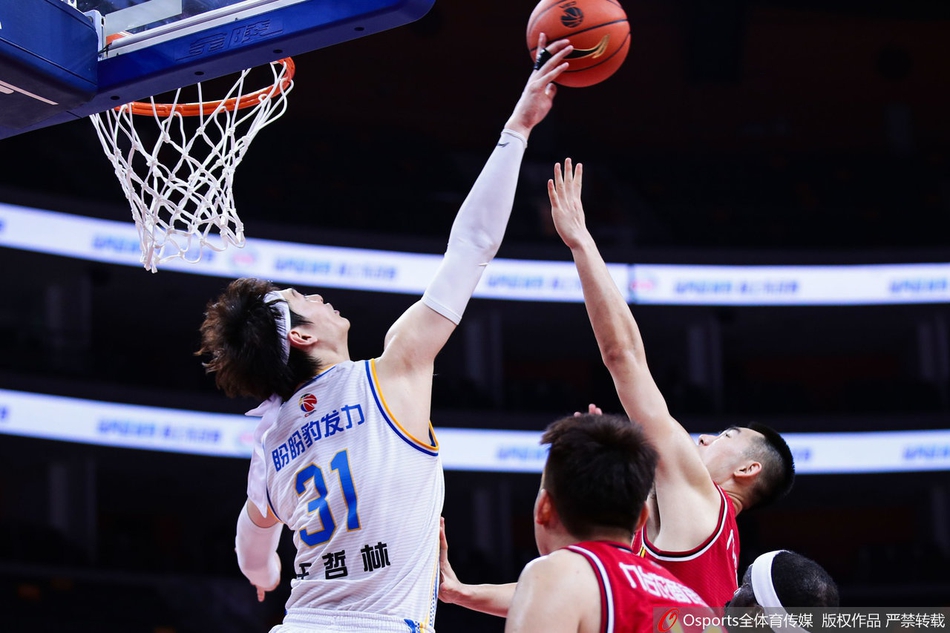 王哲林在吉林队内线群中高高跃起，犹如泰山压顶一般强行摘下进攻篮板，眼神中透露出对胜利的无限渴望。