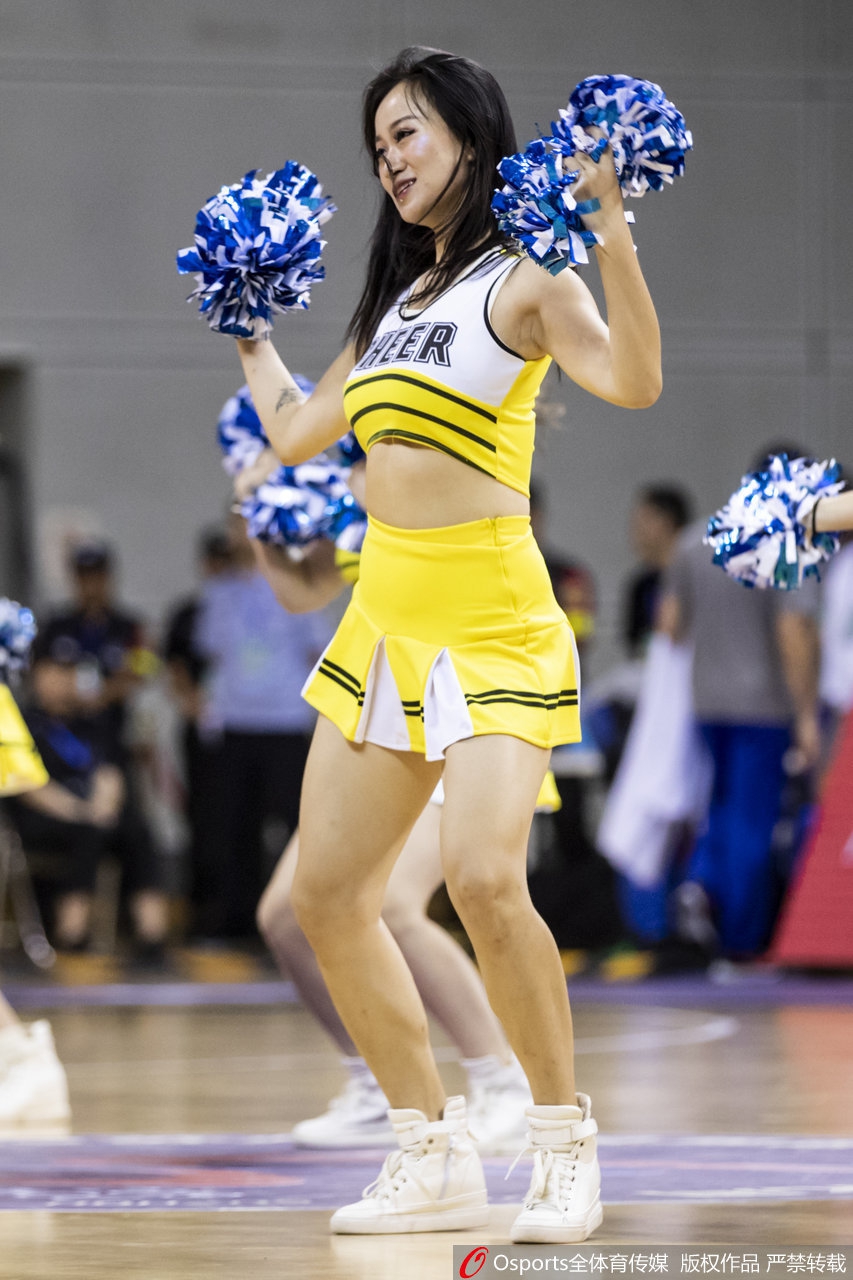镜头拉近，一位笑容甜美的啦啦宝贝在热舞间隙面对观众，额头的汗珠在灯光下闪闪发光，专注的眼神透露出她对这片赛场的热爱与敬业。
