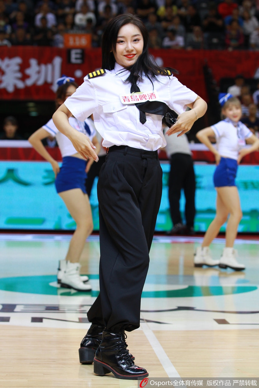 镜头拉近，这位啦啦宝贝眼神专注而明亮，精致的妆容与笔挺的制服相得益彰，她随着音乐律动的身姿，展现出一种不同于以往的优雅与飒爽。