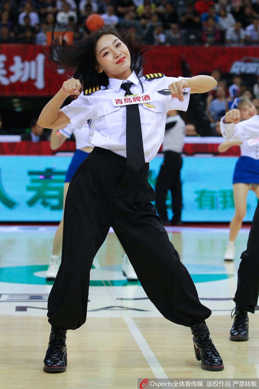 这位宝贝的侧颜堪称完美，她伸展手臂的瞬间，制服线条显得格外利落，背景是模糊的看台灯光，更衬托出她作为舞台焦点的光芒。