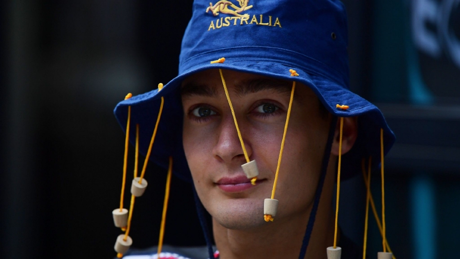 梅赛德斯车队的刘易斯·汉密尔顿驾驶着黑色赛车在直道上呼啸而过，赛车周身的气流扰动清晰可见，如同划破空气的利刃。