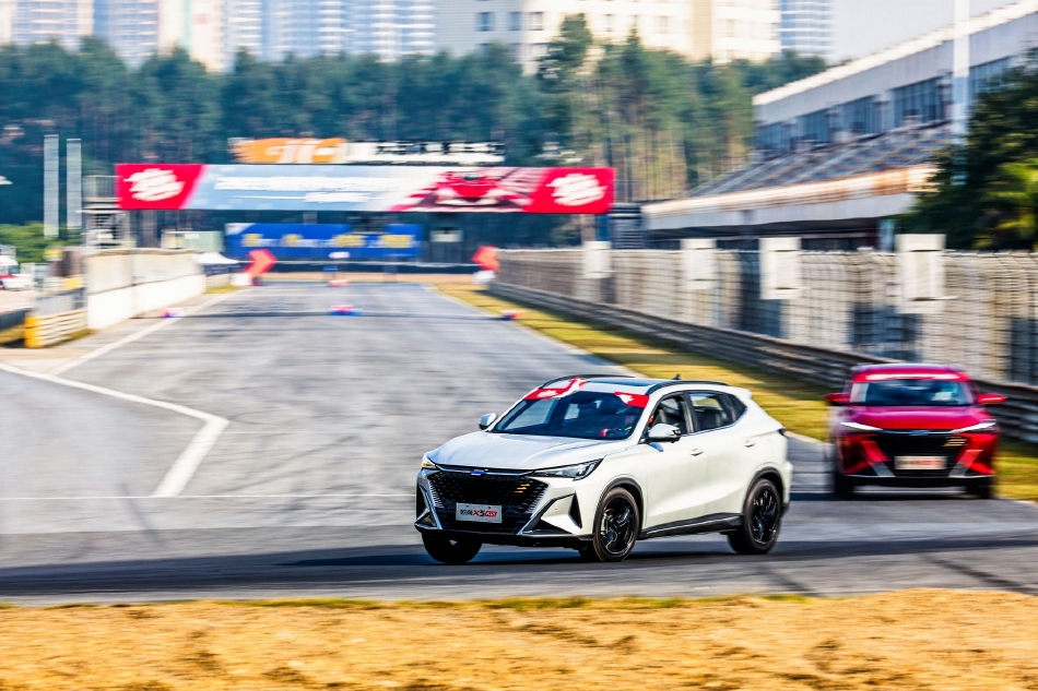 弯道中，一辆亮黄色赛车以极致角度切入，车身姿态优雅而稳定，仿佛紧贴着地面飞行。