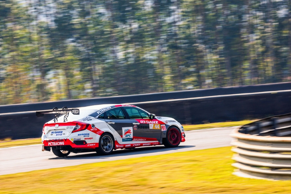 夕阳余晖为赛场披上金色外衣，赛车与人的剪影构成一幅动静结合的速度美学画面。