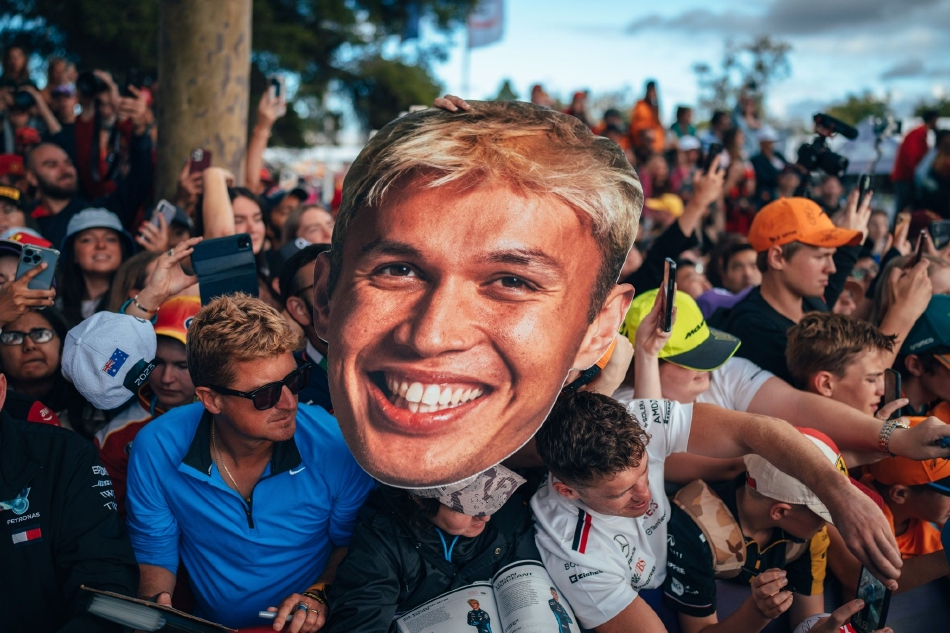 兰多·诺里斯的迈凯伦赛车驶过标志性的阿尔伯特公园赛道湖滨弯道，赛车倒映在宁静的湖面上，构成一幅力与美的动态画卷。